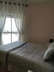 a bedroom with a large bed with a window at Casa do Paço in Almeirim