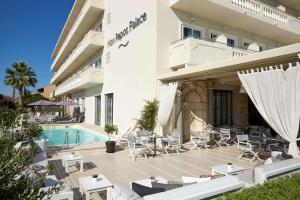 ein Hotel mit Pool, Stühlen und einem Gebäude in der Unterkunft Mon Repos Palace - Adults Only in Korfu-Stadt