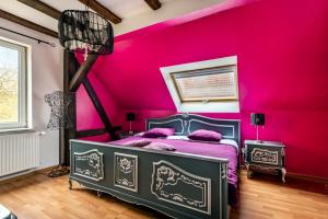 Dormitorio rosa con cama y pared de color rosa en L'Ancienne Distillerie, en Kirrwiller