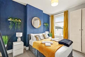 a blue bedroom with a bed and a mirror at Large Central Cardiff House - Games Room - Sleeps 12 in Cardiff