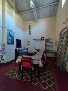 uma sala de estar com uma mesa e cadeiras num tapete em Zeus Bungalow em Kotagiri