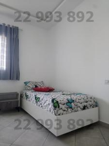 Cama en habitación con pared blanca en S2 in second position beach Dar Allouche Kelibia en Hanshīr Qaşr Ghallāb