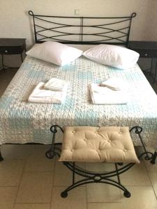 a bed with two towels and a chair on it at ARISTIDIS Apartments in Lefkimmi