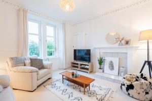 a living room with a couch and a tv at Glengate - Traditional home in Kirriemuir in Kirriemuir