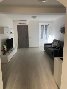 a living room with a black couch and a television at AngelhouseitalyLovereBilocale in Lovere