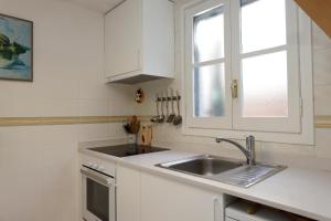 AT048 Gregal في كريكسل: مطبخ أبيض مع حوض ونافذة