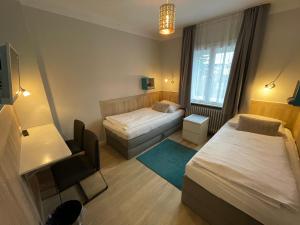 een kleine slaapkamer met 2 bedden en een raam bij ApartHotel Stadtpark in Lübeck