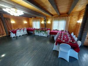 - une salle de banquet avec des tables et des chaises rouges et blanches dans l'établissement Atpūtas komplekss Burtakas, à Straupe