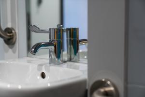 a bathroom sink with a faucet and a mirror at easyHotel Dublin in Dublin