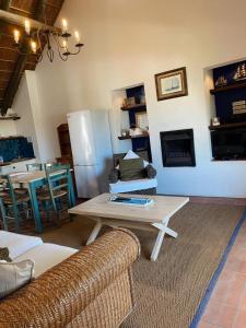 un soggiorno con tavolo e frigorifero di Breede River Lodge a Witsand