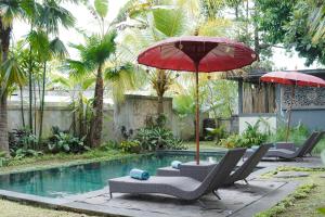 a swimming pool with chairs and umbrellas next to a pool at Sentana Villa Ubud in Ubud +36 photos