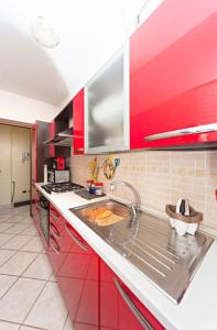 a kitchen with red cabinets and a sink at La casa di Pablo in Cinisello Balsamo