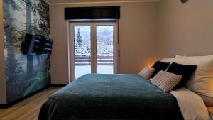 1 dormitorio con 1 cama y puerta corredera de cristal en Apartament Olimpijska 54 z prywatnym jacuzzi en Szczyrk