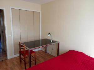 Schlafzimmer mit einem Schreibtisch, einem Bett und einer roten Decke in der Unterkunft Appartement La Rochelle, 3 pièces, 6 personnes - FR-1-551-1 in La Rochelle