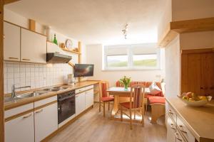 a kitchen with a table and a dining room at Gästehaus Poppler in Hopferau
