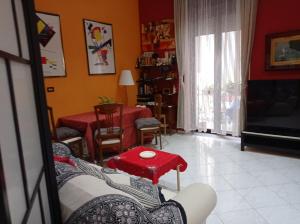 a living room with a table and a red stool at Casa Vacanza Da Andrea in Naples