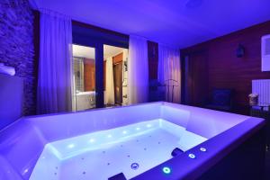 a large white tub in a room with purple lighting at Hotel Morris Premium Collection in Česká Lípa