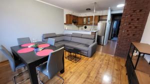 salon i kuchnia ze stołem i kanapą w obiekcie Apartament Skarbka w Warszawie