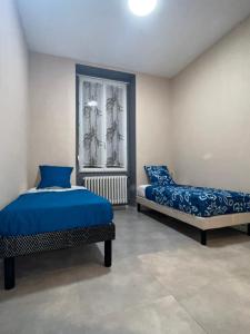 a bedroom with two beds and a window at L´ÉMERAUDE 1 in Chalons en Champagne +8 photos