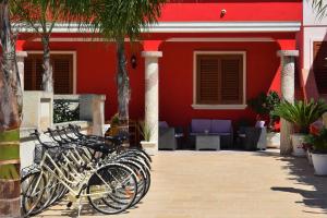 un grupo de bicicletas estacionadas frente a un edificio rojo en B&B Lizia en Porto Cesareo