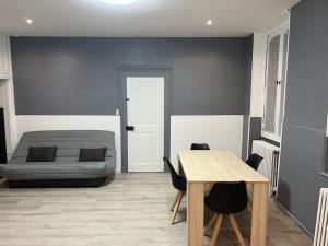 a living room with a bed and a table and chairs at L´ÉMERAUDE 1 in Chalons en Champagne
