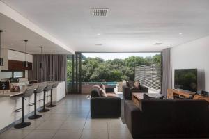 a living room with couches and a kitchen with a view at Stylish 19 Ocean's Edge 4 Bedroom Home, Zimbali in Ballito