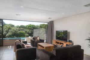 a living room with couches and a flat screen tv at Stylish 19 Ocean's Edge 4 Bedroom Home, Zimbali in Ballito