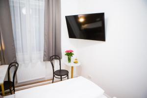 Zimmer mit einem Bett, 2 Stühlen und einem TV in der Unterkunft Pension Central I Self Check In in Wien