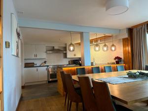 ナンダにあるChalet Christyの木製のテーブルと椅子のあるキッチンとダイニングルーム