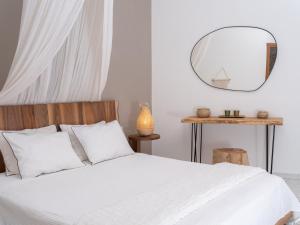 a bedroom with a white bed and a mirror at Escape In Blue in Stalida