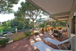 a balcony with a table and chairs and an umbrella at Appartamento Dei Ronchi in Marina di Massa