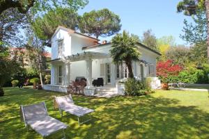 uma casa branca com duas cadeiras no quintal em Villa Poveromo em Massa