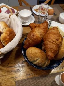 a table with a plate of bread and croissants at B&B Huize Placida in Boxmeer