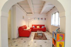 uma sala de estar com um sofá vermelho e uma mesa em Villa Poveromo em Massa
