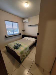 Habitación pequeña con cama y ventana en Apartamento centro Efapi ideal para trabalho ou estudo, en Chapecó