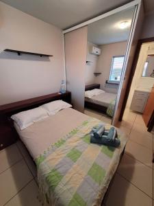 ein Schlafzimmer mit einem großen Bett und einem Spiegel in der Unterkunft Apartamento centro Efapi ideal para trabalho ou estudo in Chapecó