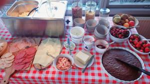 einem rot-weißen karierten Tisch mit Lebensmitteln darauf in der Unterkunft Klintholm Bed & Breakfast in Borre