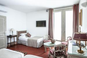 a living room with a bed and a table and chairs at Le Clos Du Buis in Bonnieux