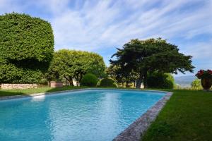 una piscina en un patio con árboles y césped en Le Clos Du Buis en Bonnieux