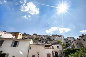 una vista de una ciudad con el sol en el cielo en Le Clos Du Buis, en Bonnieux