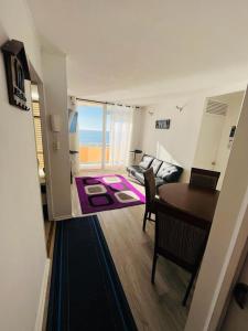 sala de estar con mesa y comedor en Departamento Playa Bellavista, estacionamiento privado, vista al mar, 2 dormitorios 3 camas en Tomé