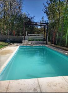 a swimming pool in a yard with a fence at Las Flores, casa del valle in Potrerillos