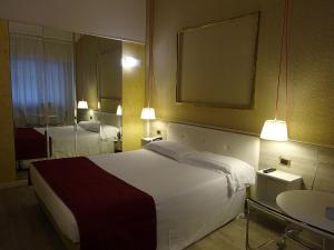 Cette chambre comprend un grand lit et un miroir. dans l'établissement 7MOTEL - Settimotel, à Settimo Milanese