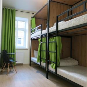 a room with two bunk beds with green curtains at FOKA Hostel in Wrocław