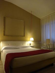 セッティモ・ミラネーゼにある7MOTEL - Settimotelのベッドルーム1室(大型ベッド1台、テーブル、椅子付)