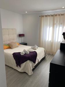 una camera da letto con un grande letto con asciugamani di Casa Berlenga a Peniche