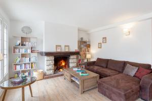 a living room with a couch and a fireplace at Au Domaine Cru in Savignies