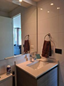 een badkamer met een wastafel en een grote spiegel bij Hermoso departamento en Viña del Mar/Casino in Viña del Mar