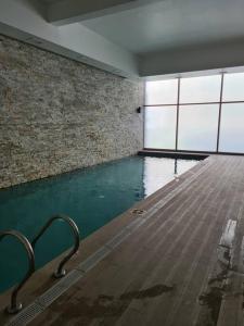 een zwembad in een kamer met een bakstenen muur bij Hermoso departamento en Viña del Mar/Casino in Viña del Mar