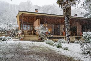 una baita di tronchi nella neve con un albero di Villa Poliziana San Benedetto a Montepulciano